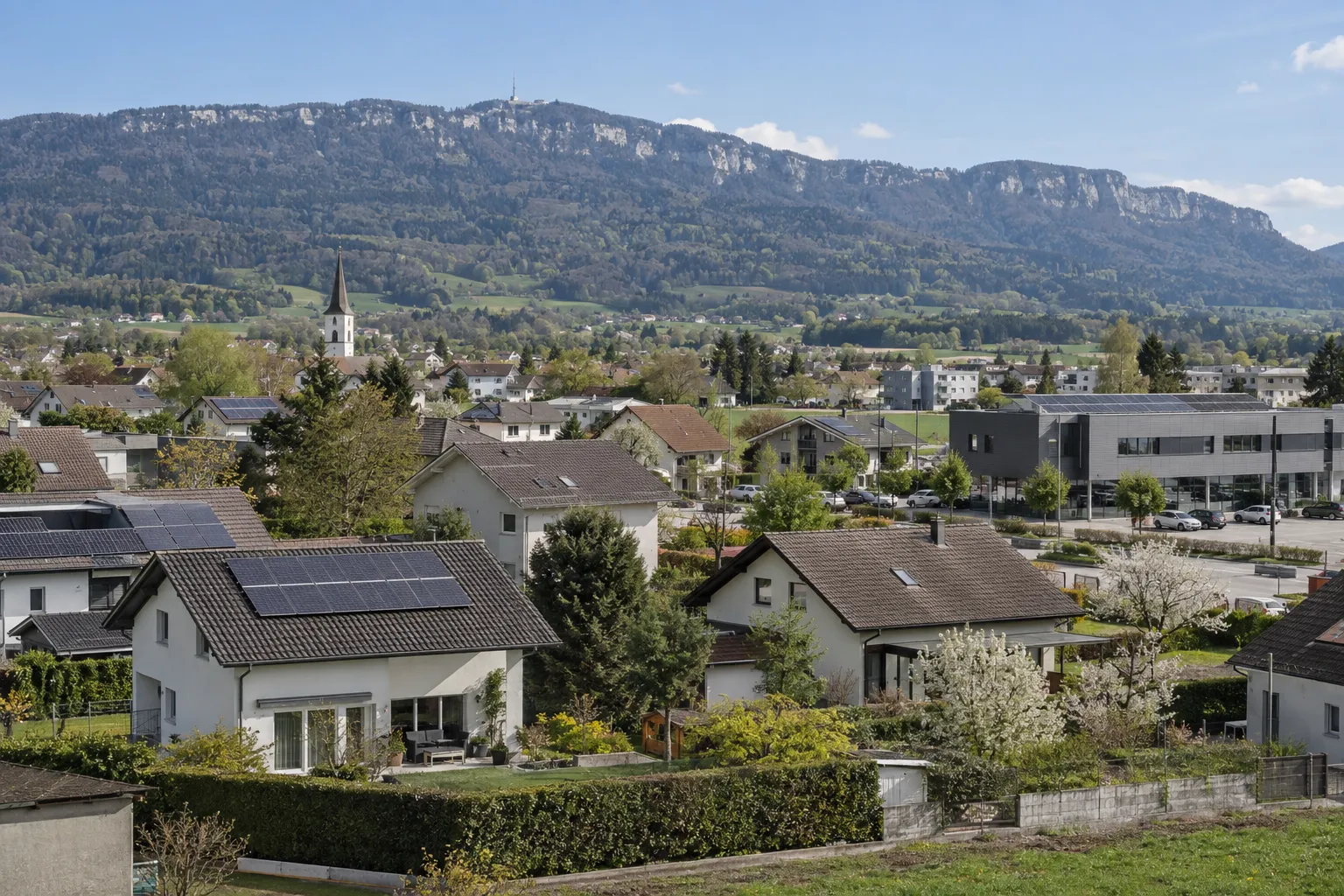 Häuser mit Solaranlagen in der Aareebene, dahinter der Weissenstein.